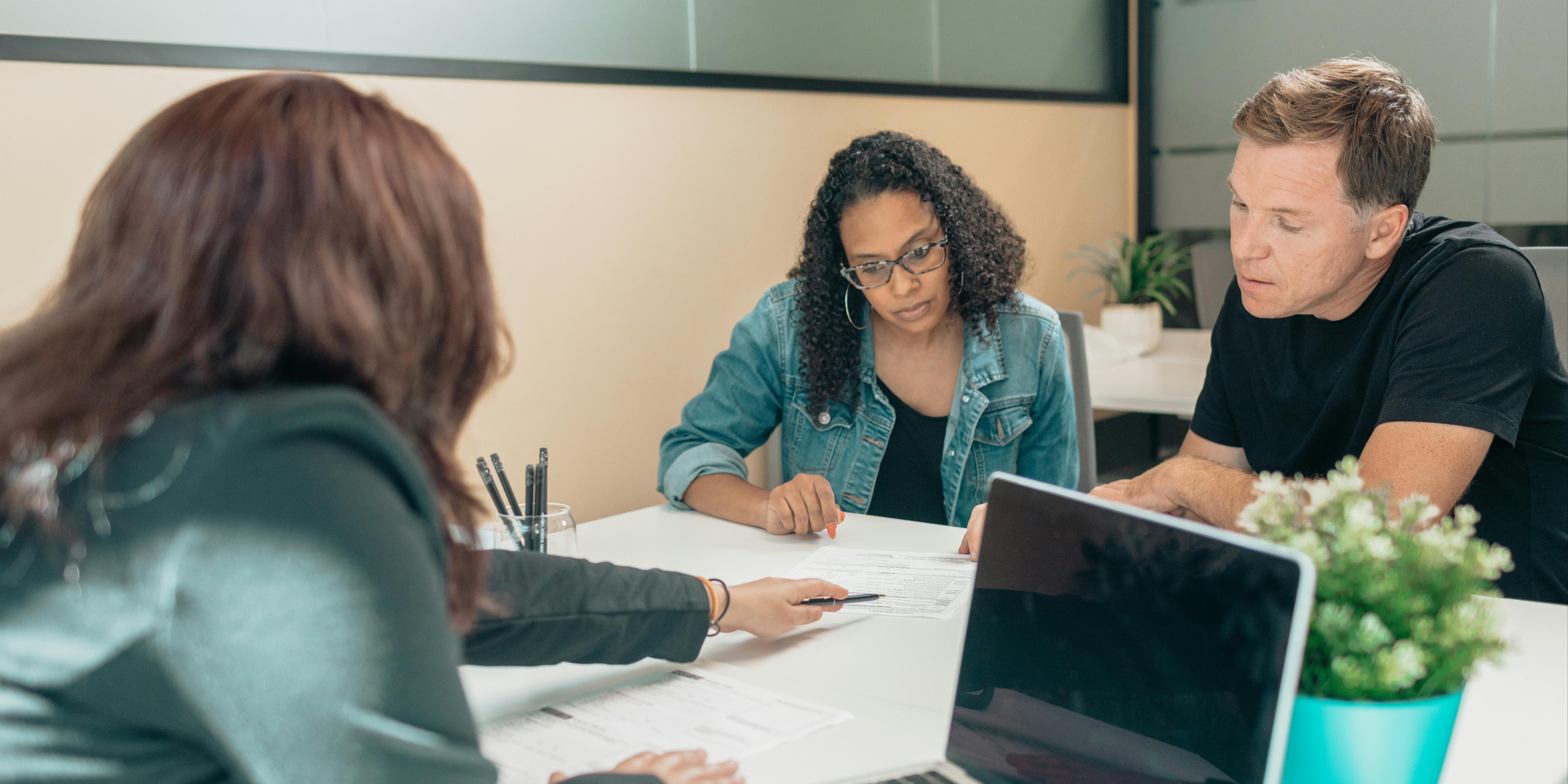a couple meets with a banker and reviews some documents