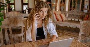 a young woman looks frustrated while making a phone call